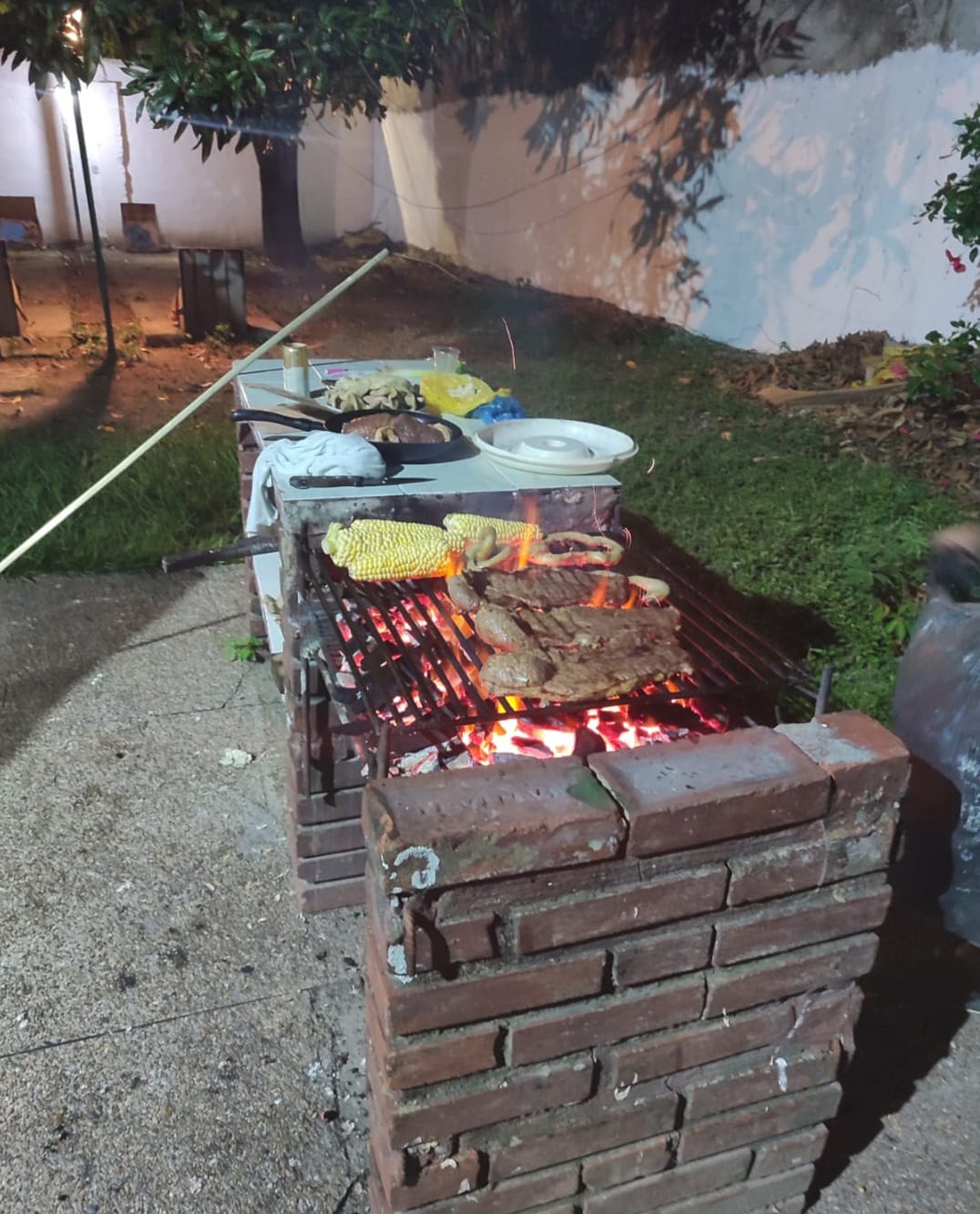 Parrilla con carnes y mazorcas asándose
